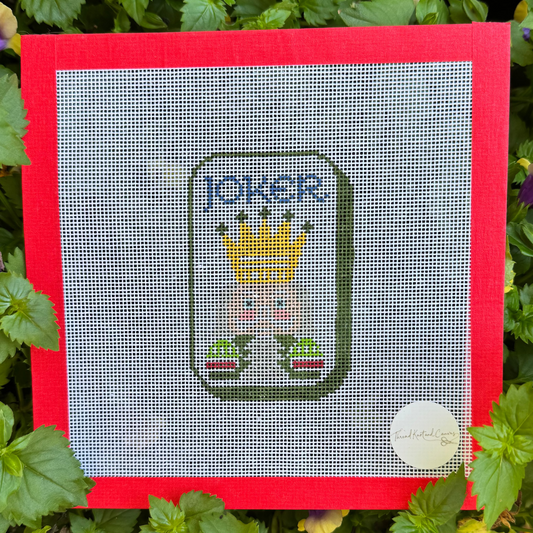 A square cross-stitch canvas featuring a Joker Mahjong Tile with a red border.  